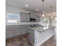 Modern kitchen boasts gray cabinets, granite countertops, stainless steel appliances, and a large island at 1579 Pecan Drive # 29, Nashville, NC 27856