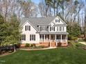 Inviting two-story home featuring a covered porch and manicured lawn at 2021 Terri Creek Dr, Fuquay Varina, NC 27526