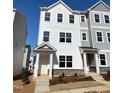 A new construction townhome featuring light color schemes and stone accents enhance curb appeal at 3007 Honeymyrtle Ln, Durham, NC 27703