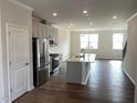 Open-concept kitchen with stainless steel appliances, a center island, and hardwood flooring at 3007 Honeymyrtle Ln, Durham, NC 27703