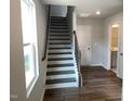 Open staircase with wood treads, iron railings, and natural light from a nearby window at 3007 Honeymyrtle Ln, Durham, NC 27703