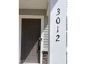 Close-up of the front door featuring the house number and a modern electronic lock for added security and convenience at 3012 Honeymyrtle Ln, Durham, NC 27703