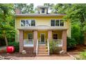 Delightful yellow home with a brick porch, white railings, and manicured landscape features classic elegance at 407A Hillsborough St, Chapel Hill, NC 27514