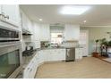 Bright kitchen with modern appliances, white cabinetry, granite countertops, and tile backsplash at 410 N Currie Dr, Sanford, NC 27330