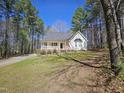 Quaint front exterior featuring a covered porch, manicured lawn, and lush landscaping, providing great curb appeal at 4116 Tall Pine Dr, Franklinton, NC 27525