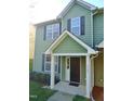 Charming two-story townhome featuring green siding, black shutters, and a welcoming covered front porch at 4425 Moss Garden Path, Raleigh, NC 27616