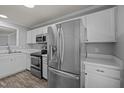 Modern kitchen features stainless steel appliances, white cabinetry, and stylish flooring at 4447 Antique Ln, Raleigh, NC 27616