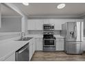 Well-lit kitchen with stainless steel appliances, white cabinets, and modern countertops at 4447 Antique Ln, Raleigh, NC 27616