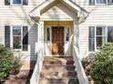 A close up of the home's front door with brick steps and white railings at 5122 Berkeley St, Raleigh, NC 27612