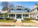 Charming two-story home featuring a welcoming front porch, landscaped yard, and blue siding at 620 Wills Forest St, Raleigh, NC 27605