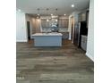 Open-concept kitchen features a gray island, stainless steel appliances, and modern pendant lighting at 628 Brittany Ct, Durham, NC 27703