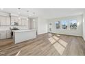 Bright, open-concept kitchen and living room area with luxury vinyl flooring and large windows at 628 Brittany Ct, Durham, NC 27703