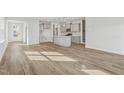 Bright, open-concept kitchen and living room area with luxury vinyl flooring and plenty of sunlight at 628 Brittany Ct, Durham, NC 27703