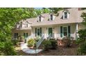 Charming home with green shutters, dormer windows and a welcoming entrance amidst lush landscaping at 63 Tally Ho Dr, Selma, NC 27576