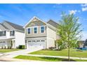 View of the two-story home with a two-car garage, set on a green lawn with blue sky at 653 Corvair Ln, Wendell, NC 27591