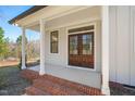 Inviting covered porch with brick steps leading to double front doors, and white pillars at 7950 Country Knoll Rd, Bahama, NC 27503