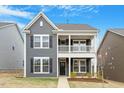 A charming two-story home featuring a covered porch and well-maintained landscaping at 813 James J Freeland Dr, Hillsborough, NC 27278