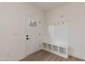 Bright entryway featuring white walls, a coat rack, and a built-in bench with storage at 100 Gates St, Roxboro, NC 27573