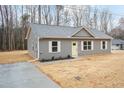 Charming single-story home with gray siding, white trim, and a bright yellow front door at 100 Gates St, Roxboro, NC 27573
