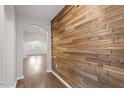 Hallway featuring a wood-accent wall, hardwood floors, and views into the living spaces at 1020 Topland Ct, Morrisville, NC 27560