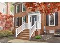 Charming brick home featuring a classic entryway with white railing and black front door at 109 S Fern Abbey Ln, Cary, NC 27518
