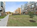Exterior view of new townhomes, featuring manicured lawns and modern architecture against a blue sky at 1234 Coach Station Alley # 101, Raleigh, NC 27601