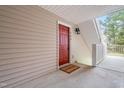 Welcoming red front door with a doormat that reads 'Welcome Home' at 1300 Hillbrow Ln # 204, Raleigh, NC 27615