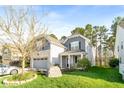 Beautiful home with a lush green lawn, mature tree, and charming exterior details, all in a well-maintained neighborhood at 1301 Elliott Ridge Ln, Morrisville, NC 27560