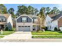Charming two-story home with a brick and gray exterior, a well-manicured lawn, and an attached two-car garage at 1301 Elliott Ridge Ln, Morrisville, NC 27560