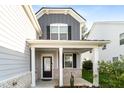Inviting front porch with white columns and a dark front door, creating a cozy entrance to the home at 1301 Elliott Ridge Ln, Morrisville, NC 27560