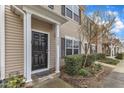 Home entrance with a black door, white trim, manicured shrubs, and a small garden bed at 1304 Cozart St # 258, Durham, NC 27704