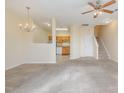 Open-concept living area showcasing carpet floors, a ceiling fan, and access to the kitchen at 1311 Canyon Rock Ct # 105, Raleigh, NC 27610