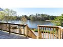 Deck overlooking lake with wood railing and stairs to the yard at 200 Nottinghill Walk, Apex, NC 27502