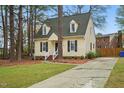 Inviting two-story home with manicured lawn, dormer windows, and a paved driveway at 204 Arnold Ln, Fuquay Varina, NC 27526