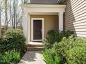 Inviting front entrance with a covered porch, decorative columns, and lush landscaping at 2217 Magnolia Tree Ln, Durham, NC 27703