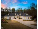 Elegant white home at twilight, highlighting its beautiful architecture and landscaping at 2223 Winston Cir, Apex, NC 27502