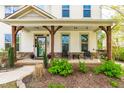 Inviting front porch with stone accents, seating, and views of the landscaped front yard at 240 Swann Trl, Clayton, NC 27527