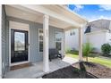 Charming covered front porch with a bench, the house number, and a black front door with glass at 245 Naples Ln, Clayton, NC 27527