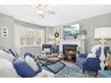 Inviting living room with hardwood floors, lit fireplace, and bright natural light at 2728 Cloud Mist Cir, Raleigh, NC 27614