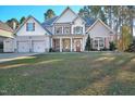 Inviting two-story home features a two-car garage, manicured lawn, and a covered front porch with stone accents at 286 Sea Mist Dr, Sanford, NC 27332