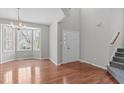 Spacious foyer featuring hardwood floors, a staircase, chandelier, and view to the front entry at 3005 Moretz Ct, Apex, NC 27502