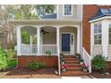 Inviting front porch with white columns, brick steps, and potted flowers leading to the front door at 3005 Moretz Ct, Apex, NC 27502
