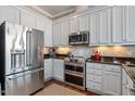 Modern kitchen with stainless steel refrigerator and appliances, complemented by granite countertops and backsplash at 317 W Morgan St # 317, Raleigh, NC 27601