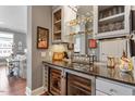 Stylish wet bar area with granite countertops, glass cabinets, and dual wine coolers for elegant entertaining at 317 W Morgan St # 317, Raleigh, NC 27601