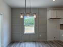 Dining area showcasing decorative wall paneling, pendant lighting, and a view of the outdoors at 4012 Kingcraig Ln, Zebulon, NC 27597