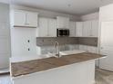 Bright kitchen featuring white cabinets, stainless steel appliances and subway tile backsplash at 4012 Kingcraig Ln, Zebulon, NC 27597