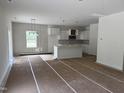 Spacious living room open to kitchen featuring white cabinets and a large island at 4012 Kingcraig Ln, Zebulon, NC 27597