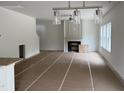 Bright living room with fireplace, large windows, and modern light fixtures at 4012 Kingcraig Ln, Zebulon, NC 27597