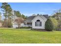 Nice house with a covered front porch, green lawn, and mature trees, providing a serene and picturesque setting at 402 Womble Dr, Lillington, NC 27546