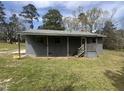 Gray home featuring covered porch with wood posts and railing, steps, and yard at 5486 B Us Hwy 301, Four Oaks, NC 27524